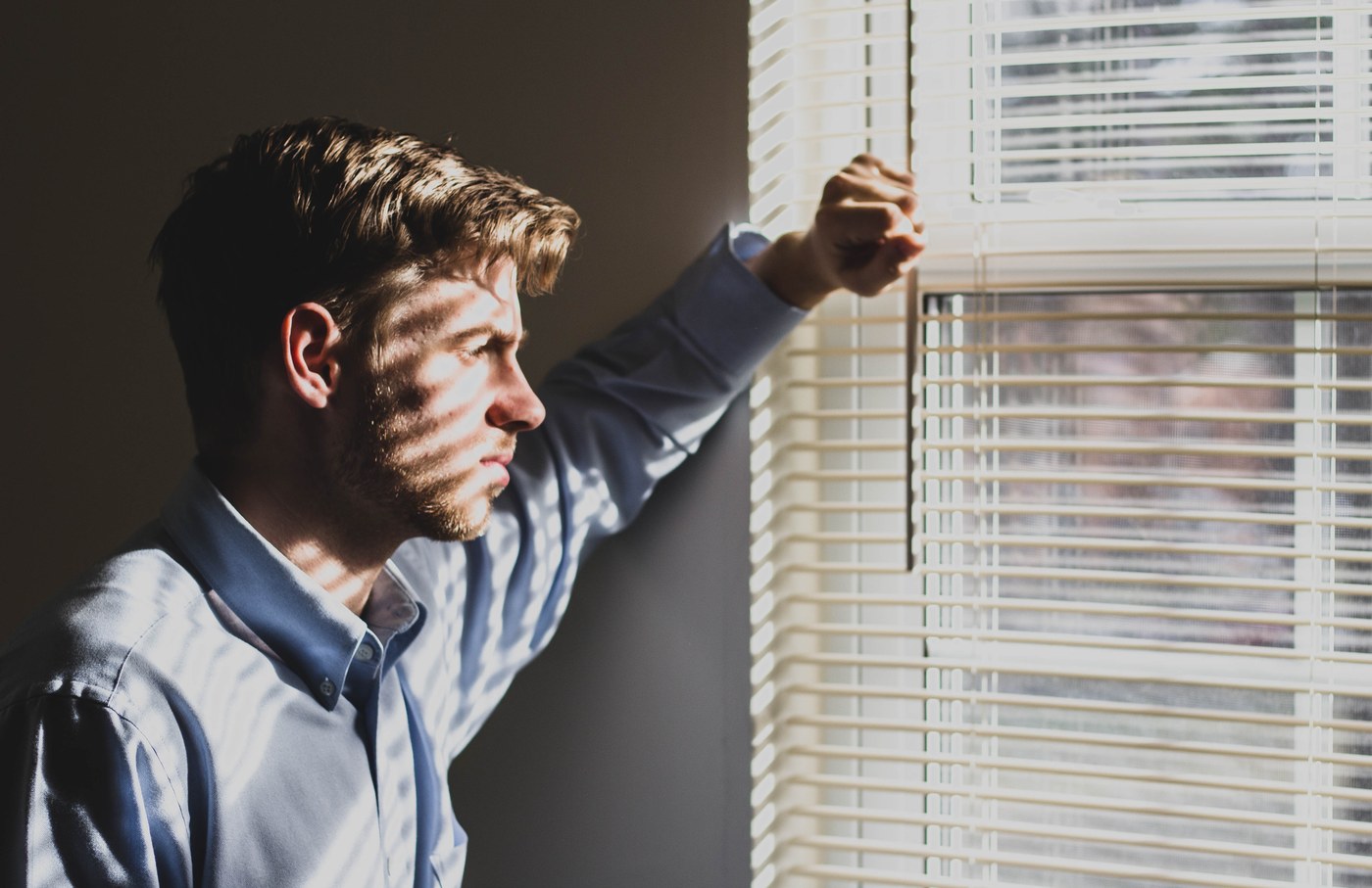 MAN LOOKING OUT OF A WINDOW